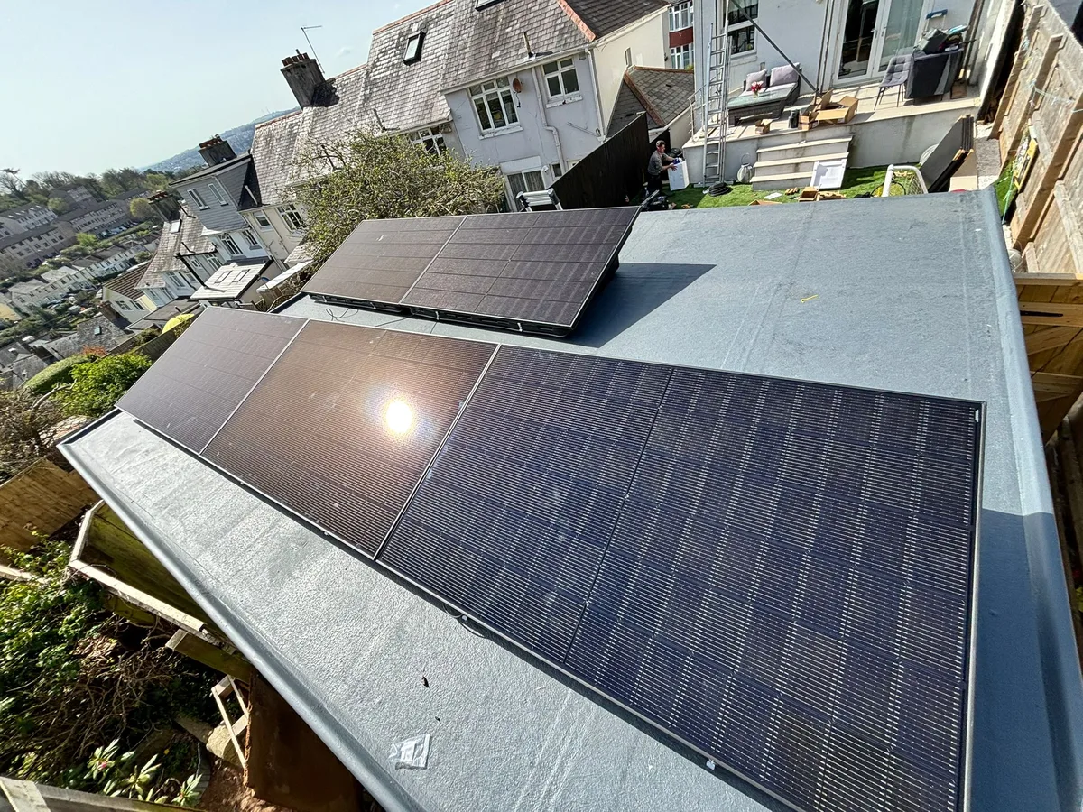 Installers fitting solar panels on a roof